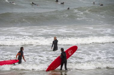 Tel Aviv, Israel - 12/15/2019: surfers training with their board on the waves of sea