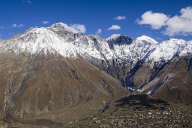 Kazbegi bölgesindeki yüksek dağlar - karla kaplı zirveler.