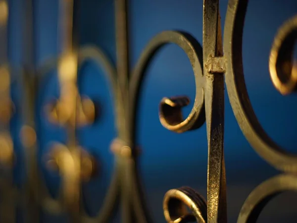 Gouden zwart gesmeed hek met krullen, perspectief — Stockfoto