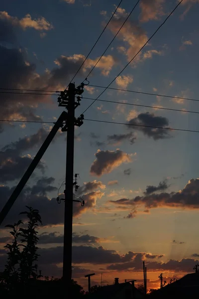 Vecchio palo elettrico su uno sfondo di cielo nuvoloso di tramonto — Foto Stock