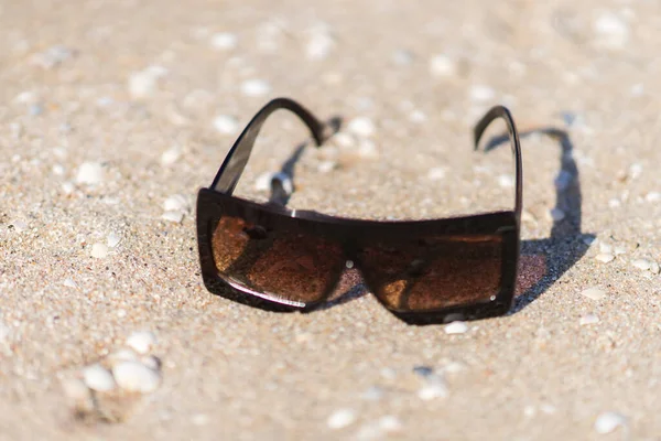 Stylish sunglasses on a sunny sandy beach — Stock Photo, Image