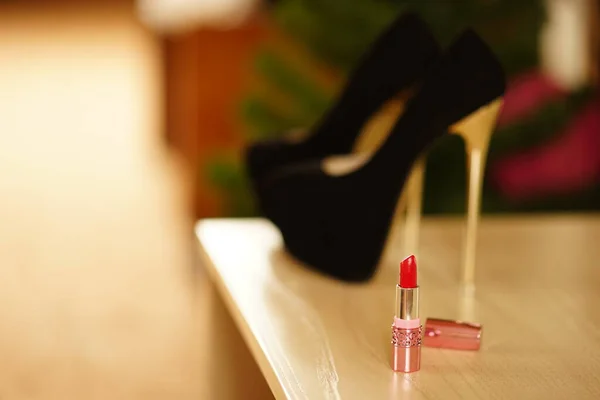 Red lipstick and high heel women shoes on the table — Stock Photo, Image