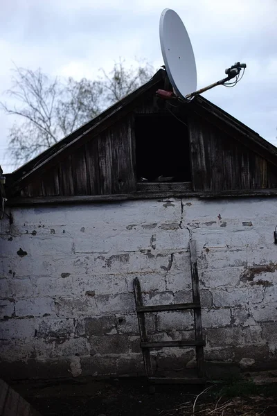 오래 된 마을 헛간에 있는 위성 안테나. — 스톡 사진