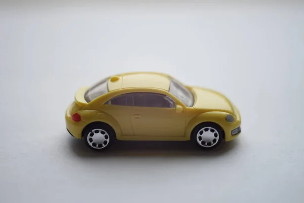 Carro de brinquedo amarelo na superfície branca, vista lateral — Fotografia de Stock