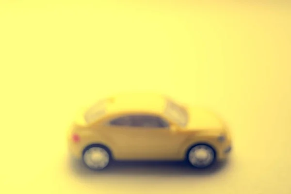 Carro amarelo desfocado em superfície enevoada ensolarada, vista lateral — Fotografia de Stock