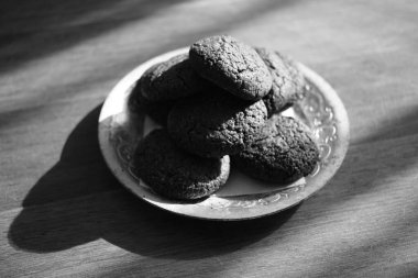 Tahta bir masada gümüş bir tabakta yulaflı kurabiyeler..