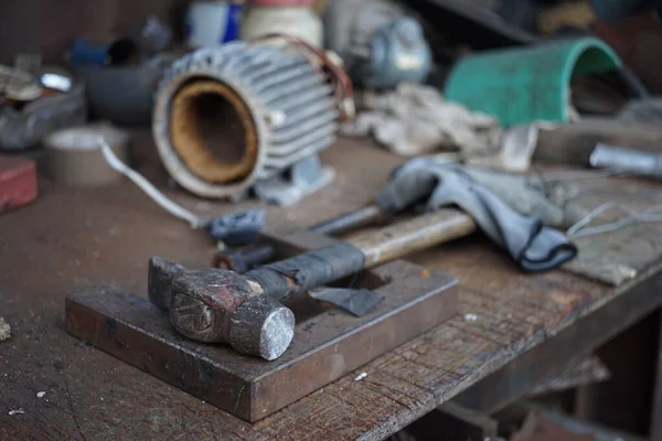 Oude hamer met een houten handvat gewikkeld in elektrisch tape op een meubelbureau. Garagegereedschap — Stockfoto
