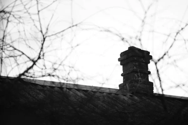 Starý cihlový komín na venkovské střeše, bw foto. — Stock fotografie