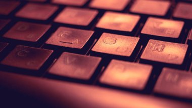 Pembe ışıkla aydınlatılan siyah klavye, makro fotoğraf.