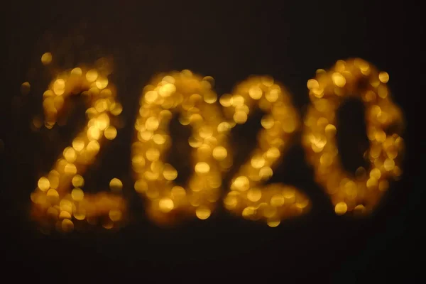 Blurred banner with a gold inscription 2020 on a black background. — Stock Photo, Image