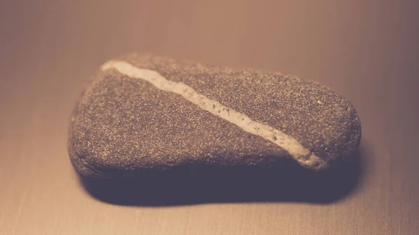 Pedra de seixo com linha branca diagonal natural na mesa . — Fotografia de Stock