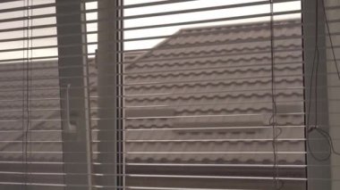 Yatay panjurları arkaplanda kahverengi kiremitli çatıyla açtık.