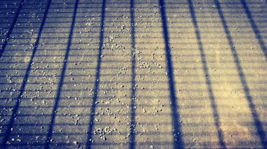 Altın taştan bir arka planda mavi dikdörtgen çizgileri olan geometrik desen.