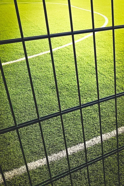 Rasenplatz zum Spielen von Minifußball hinter dem grünen Zaun. — Stockfoto