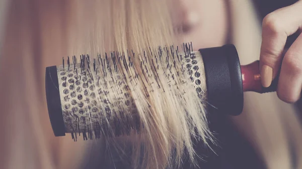 Round brushing combs long blond hair closeup. — Stock Photo, Image