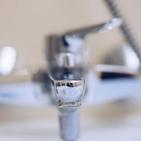 Chrome faucet in the bathroom closeup with lime, selective focus. — Stock Photo, Image