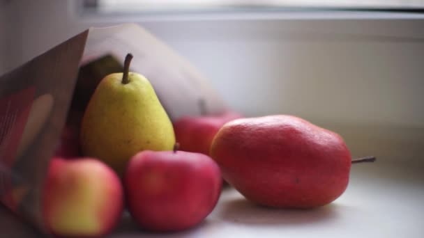在窗台上的纸袋里放上成熟的红苹果和梨 近距离侧视 — 图库视频影像