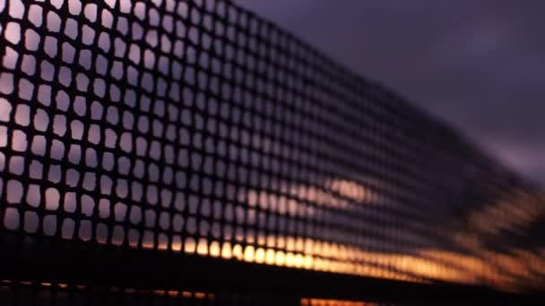 茶色の夕日の空の背景で古い錆びた鋼線メッシュフェンス — ストック動画