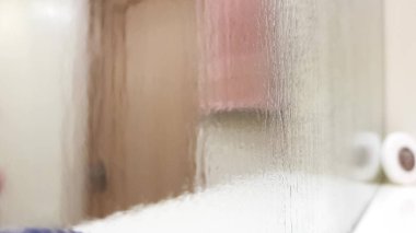 Banyo rafının üzerindeki nemli ayna, perspektif görüntüsü, yakın plan bulanık..