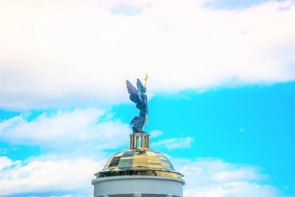 Arcanjo Michael escultura contra o céu azul com nuvens brancas, vista lateral . — Fotografia de Stock