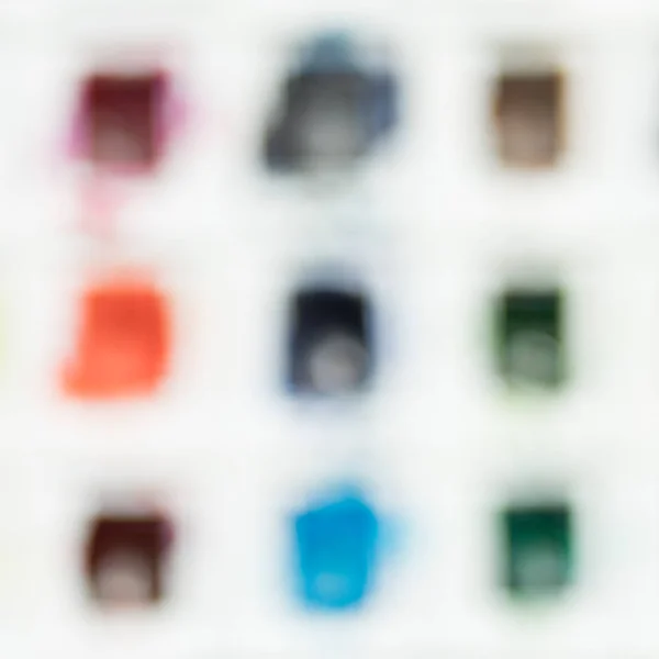 Blurred background of a watercolor set paints with different colors. — Stock Photo, Image