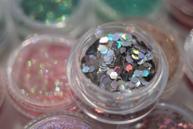 Plastik paketlemedeki farklı payetler, tırnak tasarımı için malzemeler.