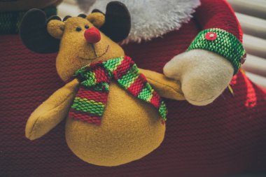 Neşeli gülüşü ve Noel Baba eli neşeli geyik yumuşak oyuncağı.
