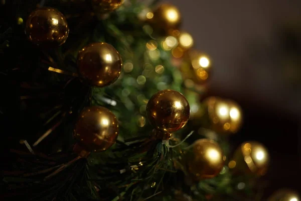 Kerstboom met gouden ballen in donkere kamer — Stockfoto