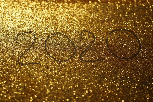 Backboden mit handgezeichneter Inschrift 2020 auf goldglänzendem Sand. — Stockfoto