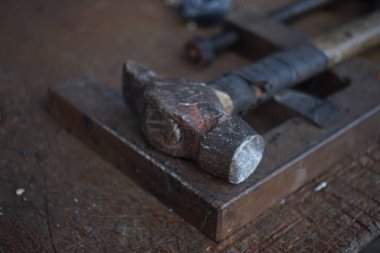 Eski çekiç, ahşap saplı ve bantla sarılmış..