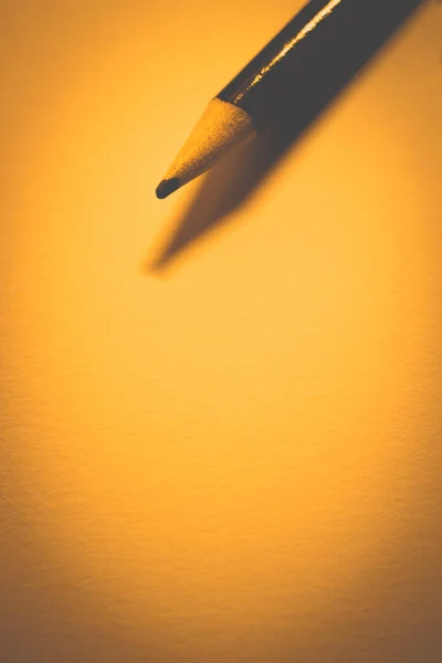 Lápis sobre papel limpo, tom morno laranja, espaço de cópia . — Fotografia de Stock