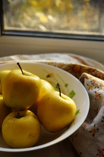 Natural yellow apples in a plate on a windowsill, organic fruits. — 스톡 사진