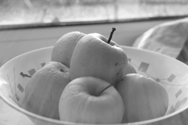 Natural apples in a plate on a windowsill, organic fruits, bw photo. — Stock Photo, Image