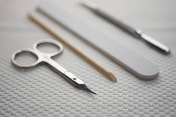 Conjunto de ferramentas para manicure na mesa, tesoura, arquivo de unhas, bastão laranja, pá de cutícula . — Fotografia de Stock