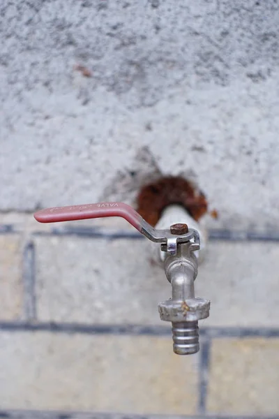 Robinet d'eau en fer dans le mur d'un bâtiment . — Photo