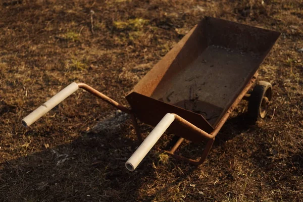 Old rusty trolley on wheels standing on the ground with dry grass. — 스톡 사진