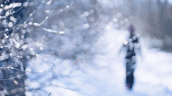 Winterbos. Silhouet van een eenzaam persoon in het zwart lopend op de weg. — Stockfoto