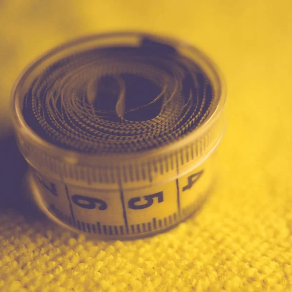 Yellow measuring tape in box on the table — Stock Photo, Image