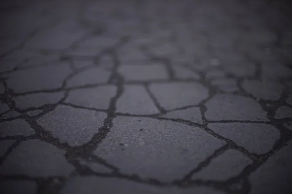 亀裂と古いアスファルトで作られた古い道路表面. — ストック写真