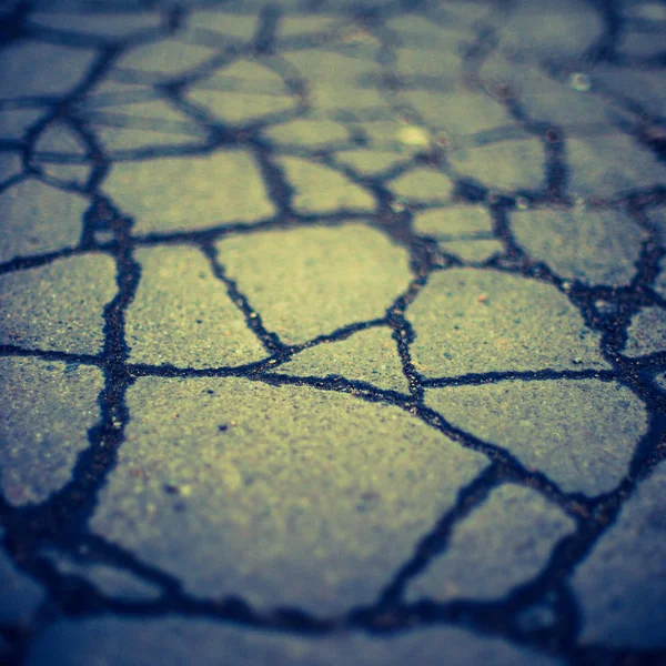 Eski asfalt yol yüzeyinde çatlaklar var. Taş dokusu — Stok fotoğraf