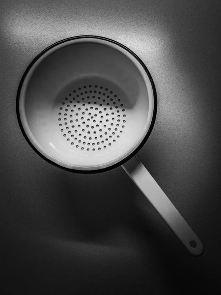 Coador de ferramentas de cozinha com uma alça na mesa escura, vista superior . — Fotografia de Stock