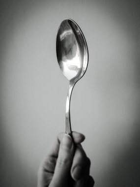 Gümüş çatal genç bayan parmakları yakın plan, bw fotoğraf.