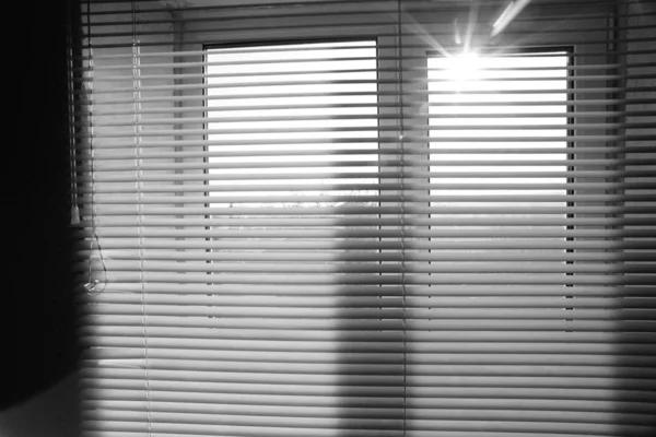 Solen skiner utomhus. Fönster med persienner i rummet. — Stockfoto
