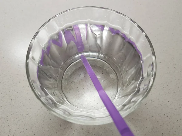 Vaso lleno de agua con tubo de bebida púrpura sobre la mesa — Foto de Stock