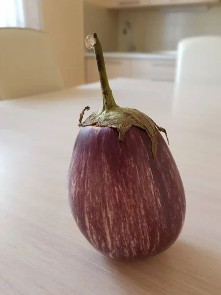 Purple eggplant with white stripes, pear-shaped on the kitchen t — Stock Photo, Image