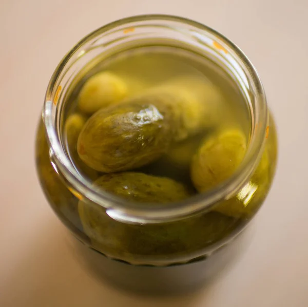 Pickled cucumbers in open jar closeup on the table