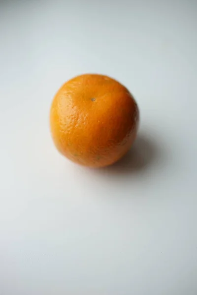 Ένα Ώριμο Μανταρίνι Πορτοκάλι Στο Λευκό Τραπέζι — Φωτογραφία Αρχείου