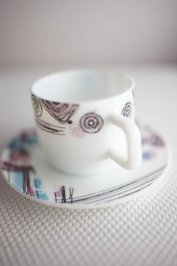 Masa örtüsü desenli fincan ve çay tabağı. Çay için modern çanak çömlek. Seçici sanat odağı