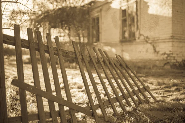 Yazın eski ahşap çit ve kır evi. Sepya retro tarzı