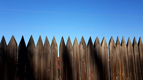 Ogrodzenie Wykonane Ostrych Drewnianych Kołek Niebieskie Czyste Niebo Słoneczny Dzień — Zdjęcie stockowe